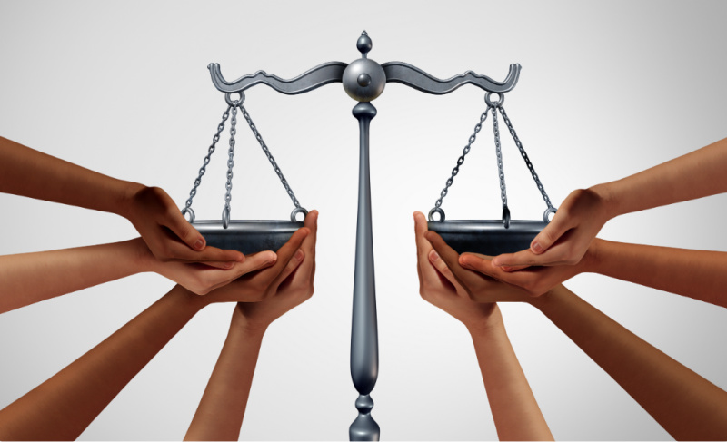 Multiple hands holding the pans of a balanced scale, symbolizing fairness, equality, or justice.